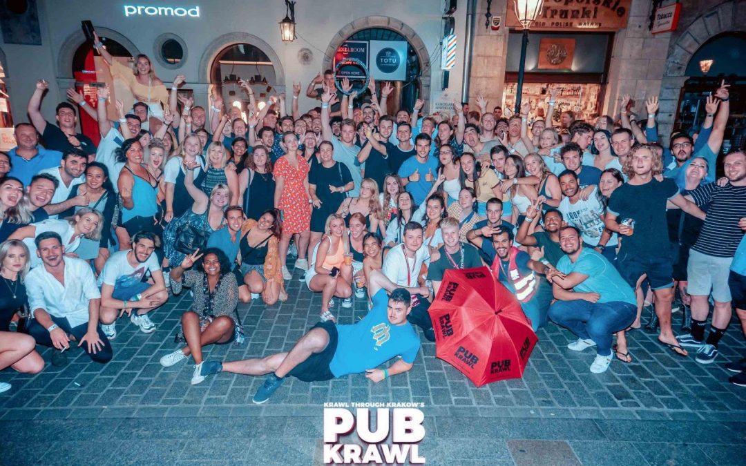 A group of people enjoying a weekend in Krakow, posing for a photo in front of a pub.
